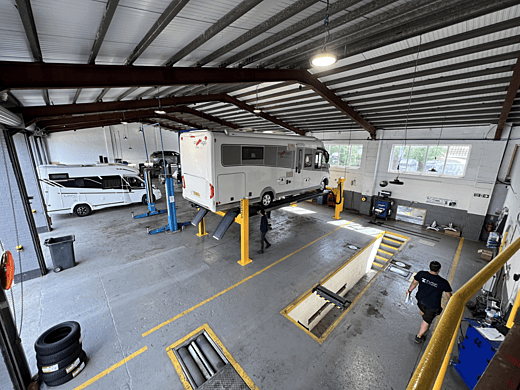 Motorhome in workshop on lift
